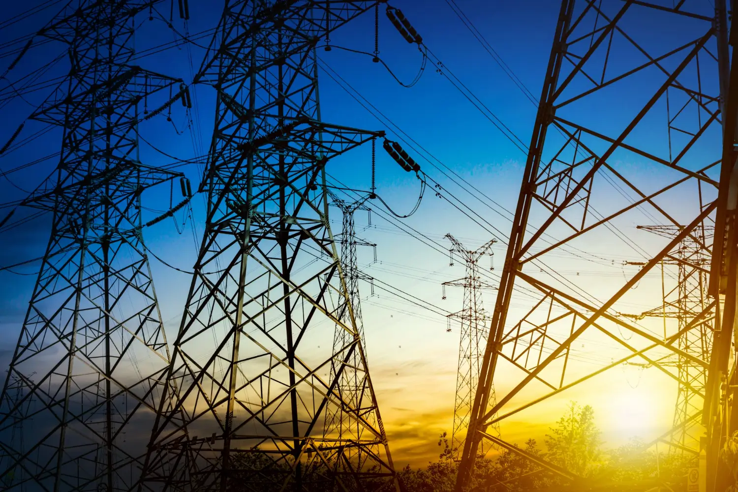 Torres de transmissão de energia contra o céu ao pôr do sol